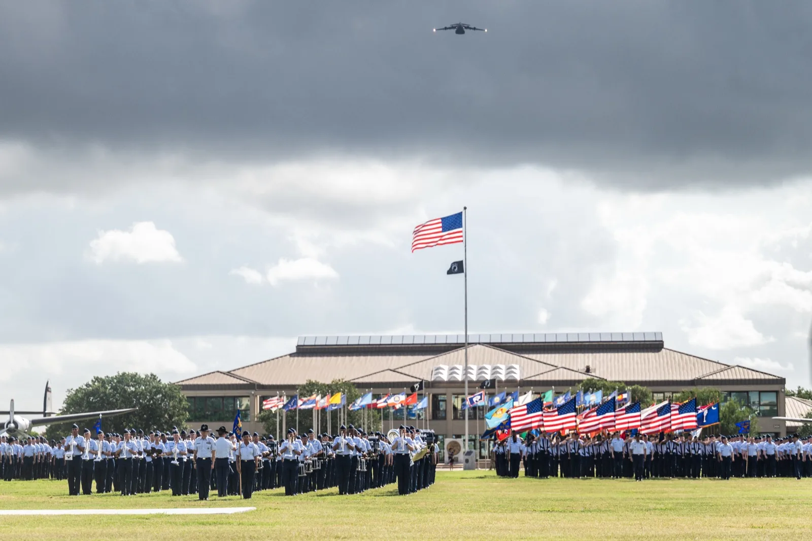 BMT graduation parade at JBSA-Lackland with Airmen marching in formation on the grass field