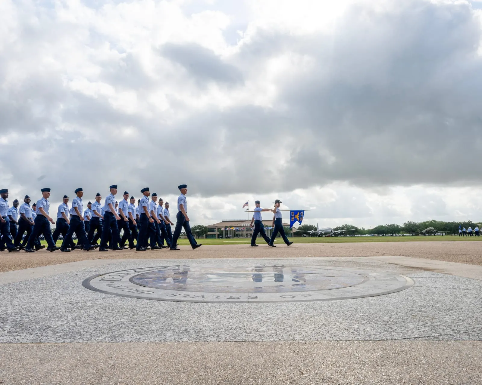 Airmen marching across the Air Force seal during BMT graduation at JBSA-Lackland